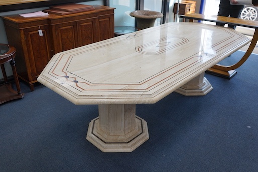 A Travertine marble dining table of elongated octagonal form on twin octagonal column supports, length 260cm, depth 120cm, height 74cm